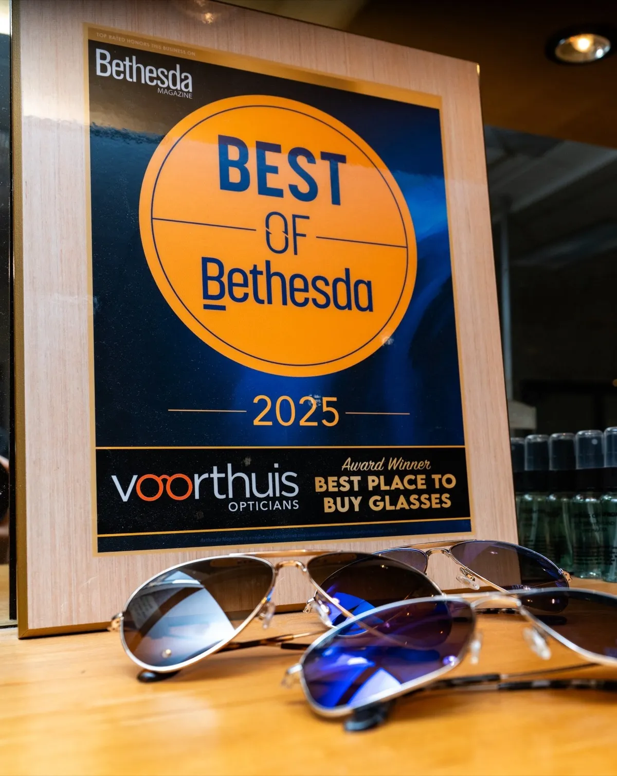 Voorthuis Opticians' Best of Bethesda 2025 'Best Place to Buy Glasses' award plaque with sunglasses in front