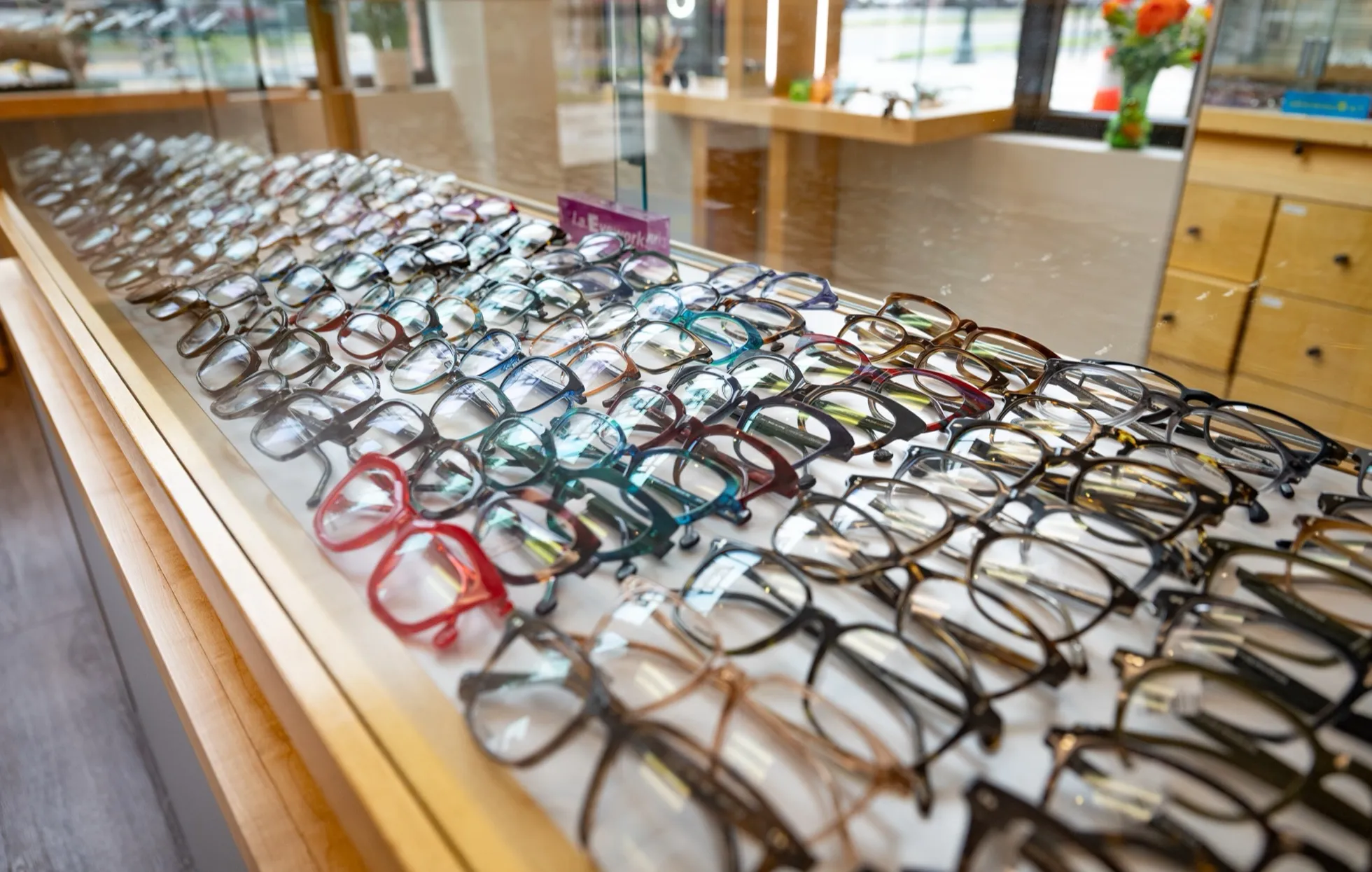 A long lit display case of designer eyewear frames at Voorthuis Opticians.