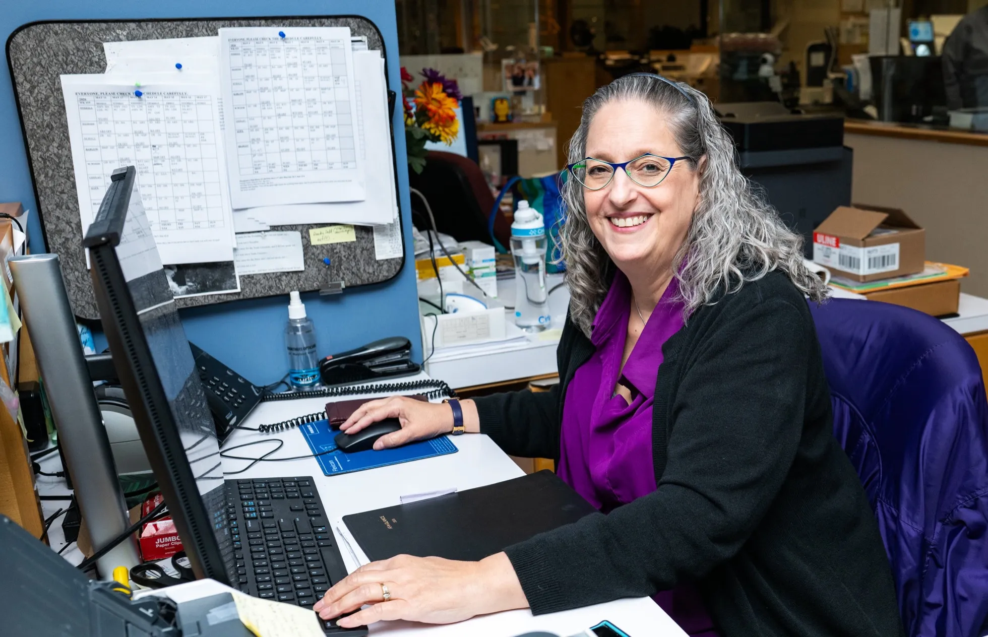 A Voorthuis Opticians staff member at the front-desk workstation.