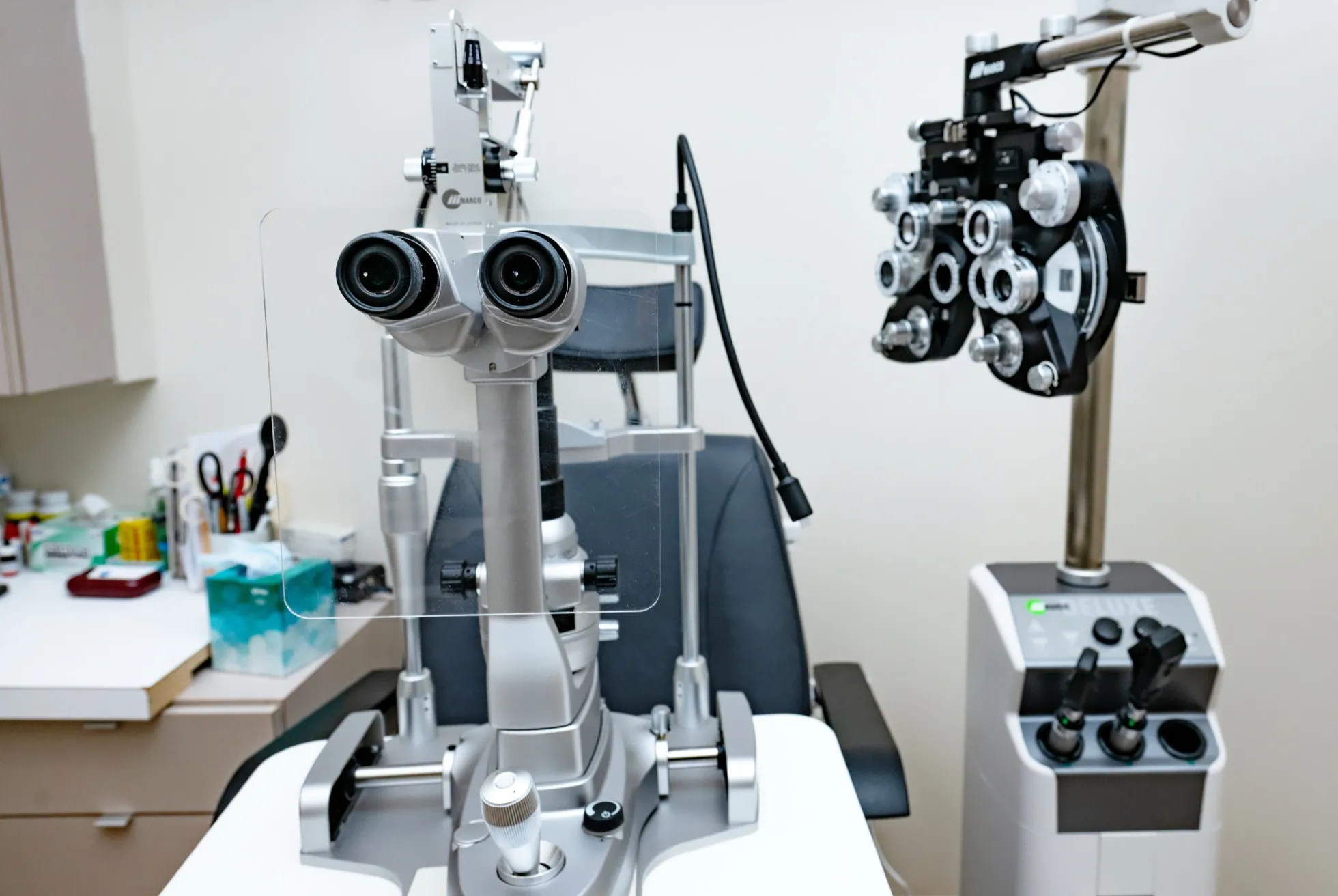 A slit lamp and phoropter in a Voorthuis Opticians eye exam room.