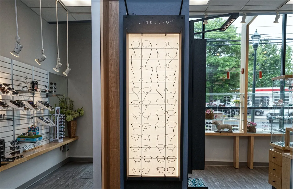 A lit Lindberg-branded frame display tower by the storefront window at Voorthuis