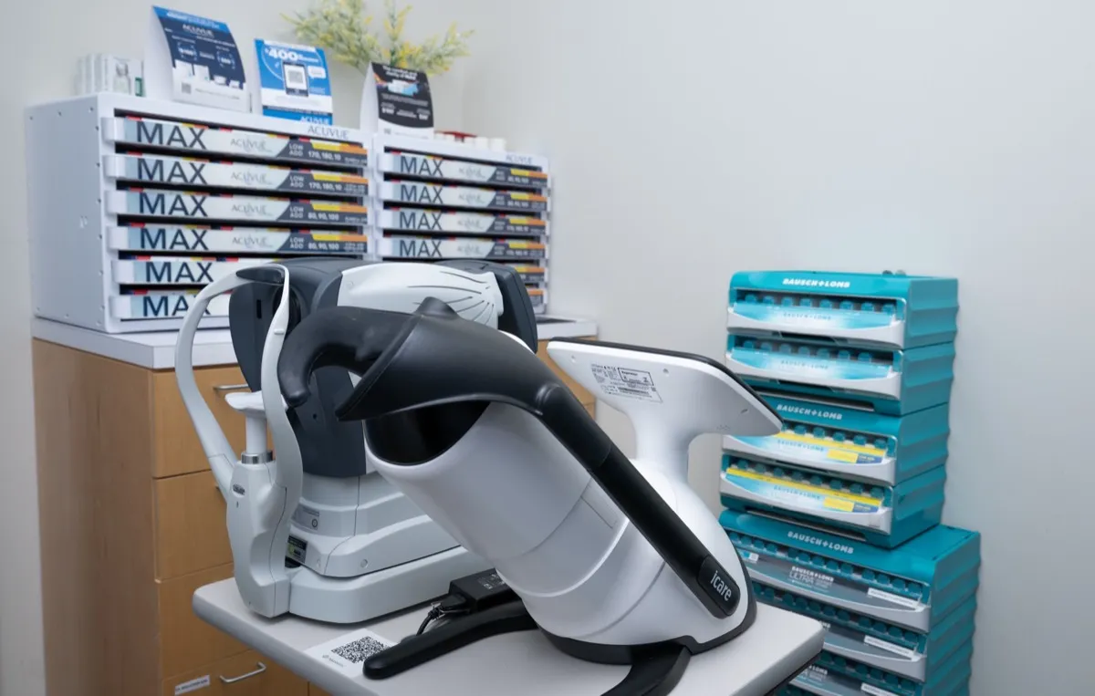 Contact lens diagnostic equipment beside stacked trial-lens boxes in a Voorthuis exam room