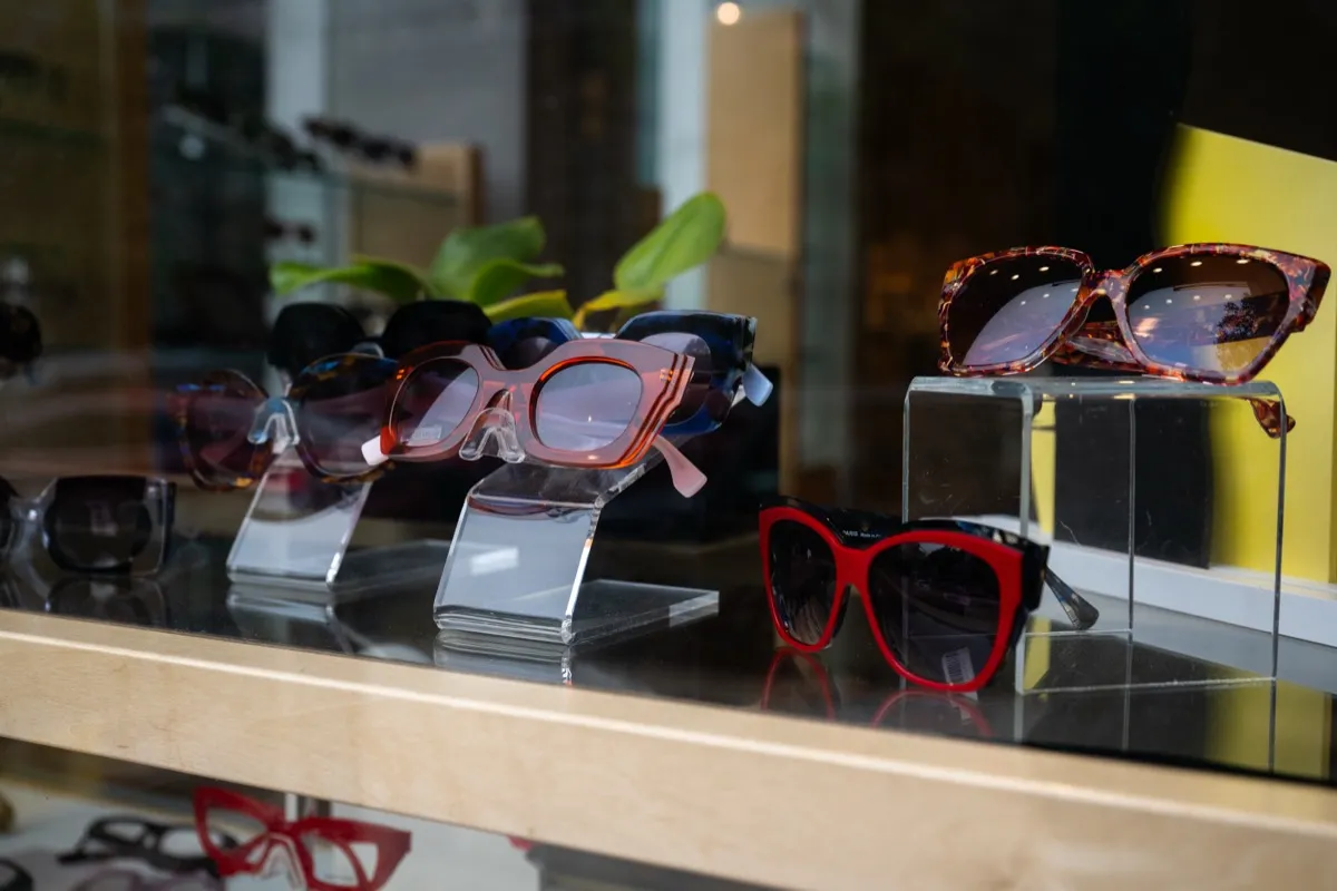 Colorful designer sunglasses on acrylic risers in a Voorthuis window display